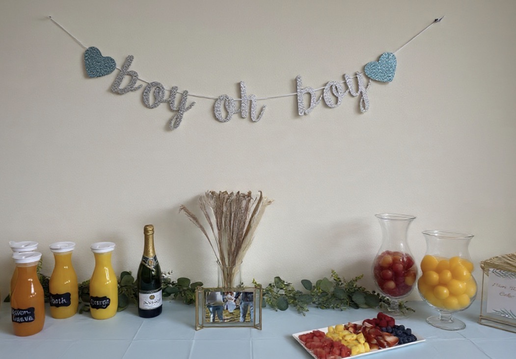 Boy oh boy banner over a mimosa and fruit spread